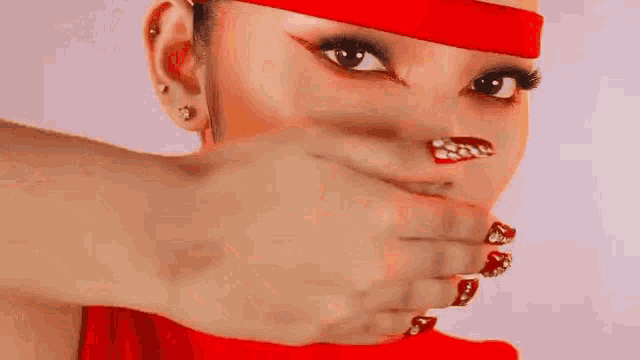 a close up of a woman covering her mouth with her hands .