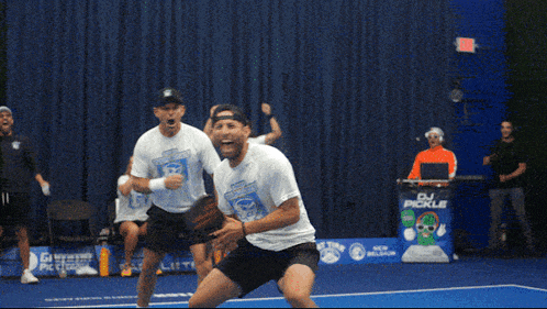 a dj pickle stands behind a group of athletes