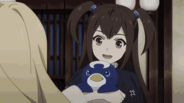 a girl with pigtails is holding a stuffed penguin with the letter c on it