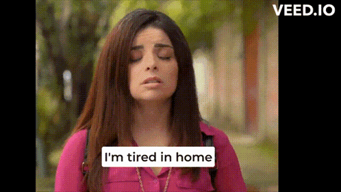 a woman says i 'm tired in home in a pink shirt