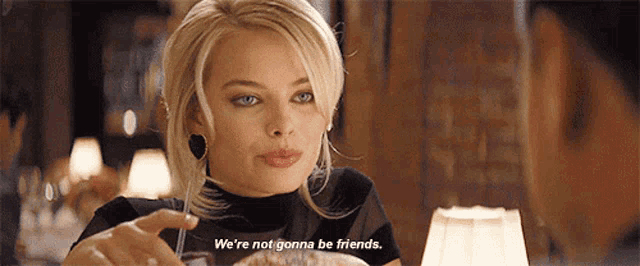 a woman is sitting at a table with a man and says we 're not gonna be friends