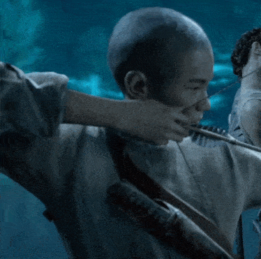 a man with a shaved head is holding a rifle