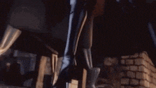 a close up of a person holding a sword in front of a wall .