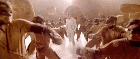 a man in a white suit is standing in the middle of a crowd of people .