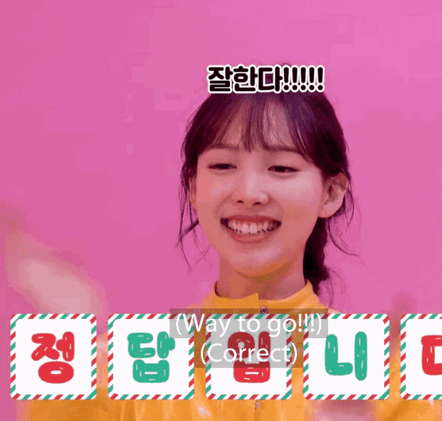 a girl in a yellow shirt is smiling in front of a sign that says " way to go correct "