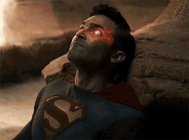 a man in a superman costume with red eyes and a s on his chest