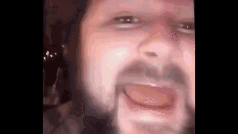 a man with a beard is making a funny face .
