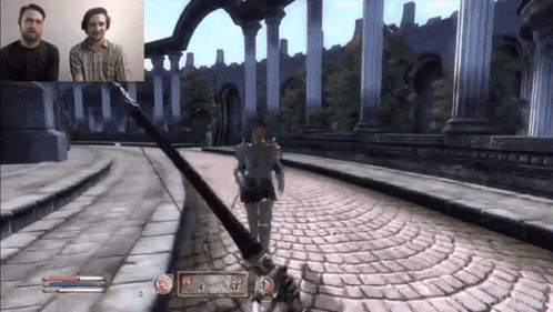 two men are playing a video game and one of them has the letters e and s on the screen