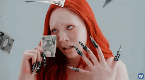 a woman with red hair and long nails is holding a 100 bill