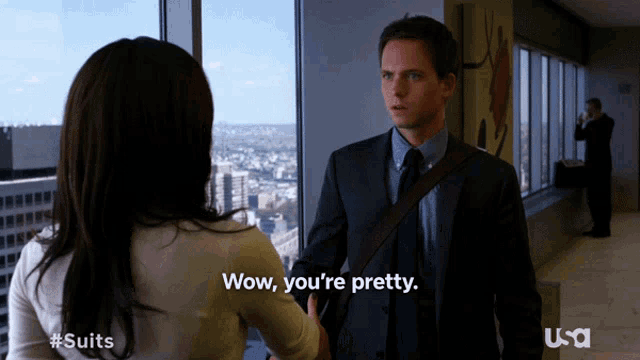 a man in a suit and tie is talking to a woman who says wow you 're pretty ..