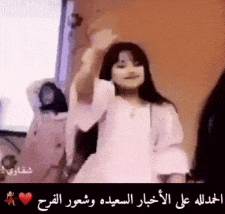 a little girl in a white dress is dancing in a room