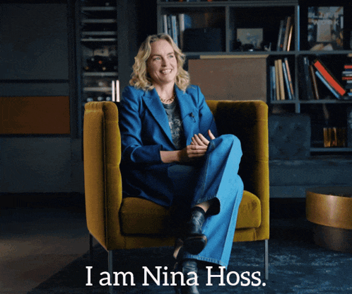 a woman in a blue suit sits in a yellow chair with the words " i am nina hoss " below her