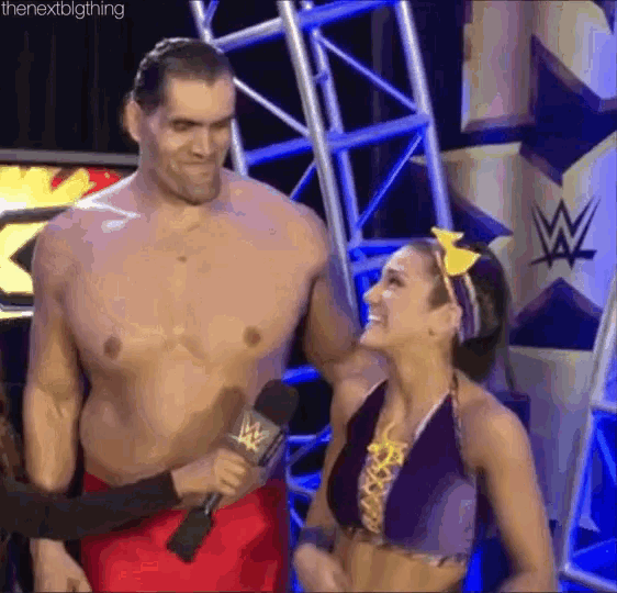 a man and a woman are standing next to each other and the woman is wearing a headband .