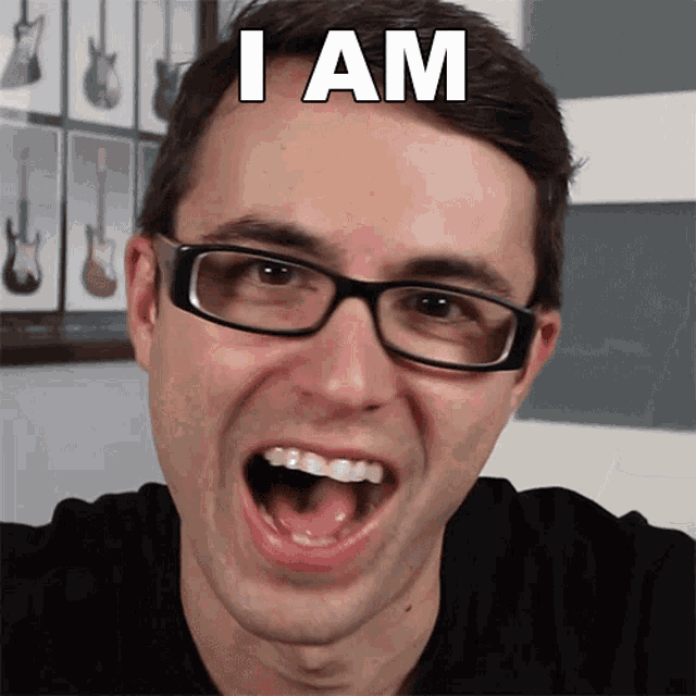 a man wearing glasses is making a funny face with the words " i am " on his head