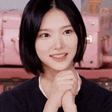 a close up of a woman 's face with pink suitcases in the background