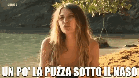 a naked woman is standing on a beach with the words un po ' la pezza sotto il naso written below her