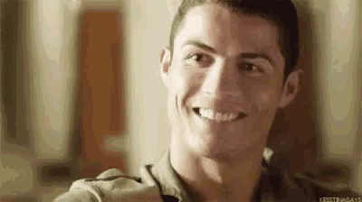 a close up of a man smiling with his mouth open and his teeth showing .
