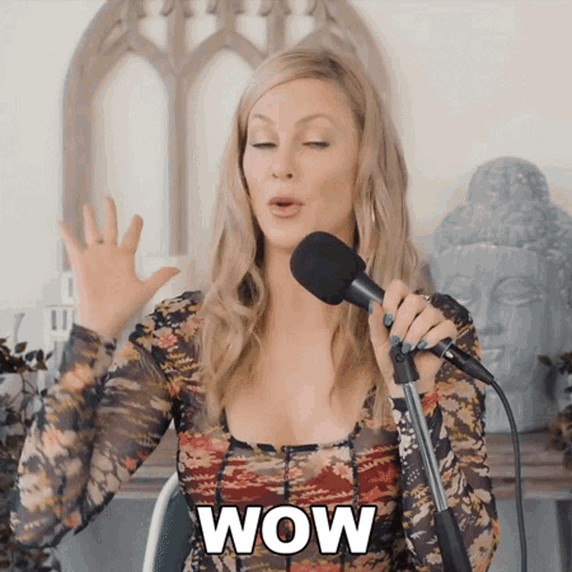 a woman is singing into a microphone and the word wow is on the bottom