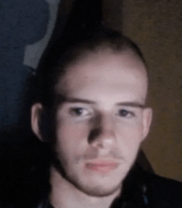 a man with a beard and a bald head looks at the camera