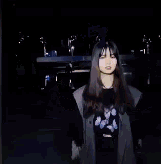a woman is standing in the dark holding a cup of coffee .