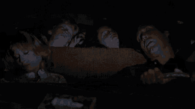 a man is sleeping in the back seat of a car while two children look on