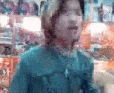a blurry picture of a person 's face with a blue shirt on