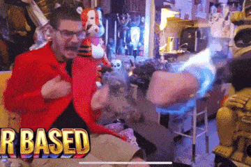 a man in a red jacket is sitting in front of a screen that says " r based "