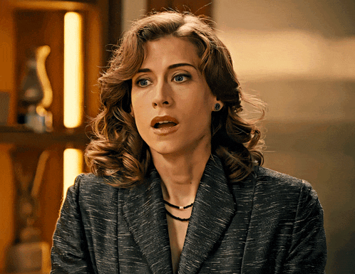 a woman with a surprised look on her face is wearing a suit