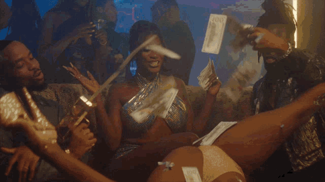 a woman in a bikini is laying on a couch with a lot of money on her legs