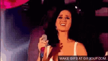 a woman singing into a microphone with a make gifs at gifsoup.com watermark
