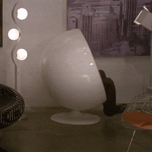 a person sits in a white chair in front of a picture of a city