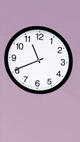 a black and white clock on a purple background shows the time as 5:05