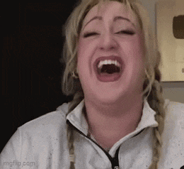 a woman is laughing with her mouth wide open and her eyes closed .