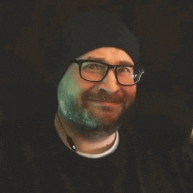 a man with glasses and a beard is smiling and says who 's your daddy ?