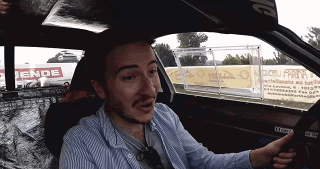 a man sits in a car with a sign that says ende on it