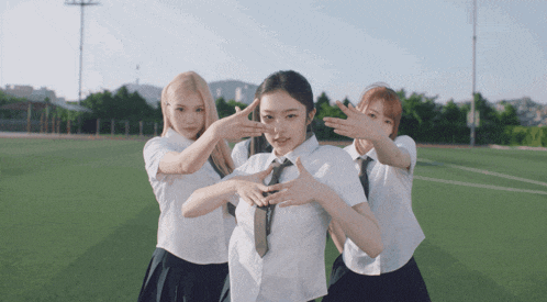 three girls wearing school uniforms and ties are posing for a picture