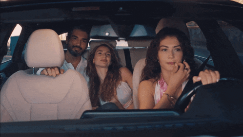 a man and two women are in a car