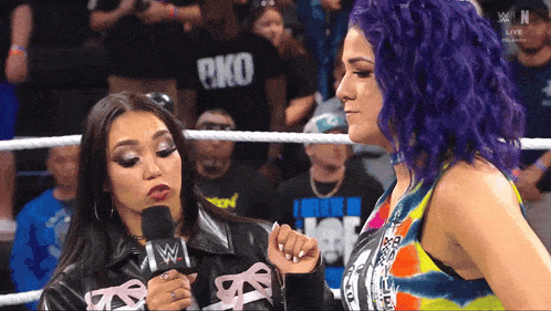 two women in a wrestling ring with one wearing a shirt that says ecko