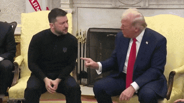 a man in a black shirt is pointing at a man in a suit
