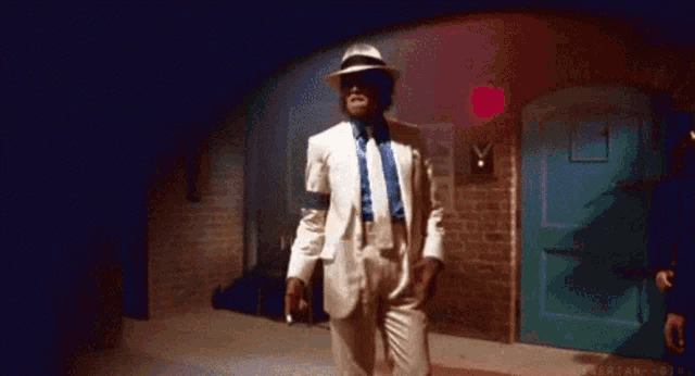 a man in a white suit and hat is standing in front of a door