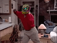 a man in a red shirt is dancing in a living room with a lamp