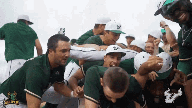 a group of men wearing green shirts and white hats with a bullpen logo in the background