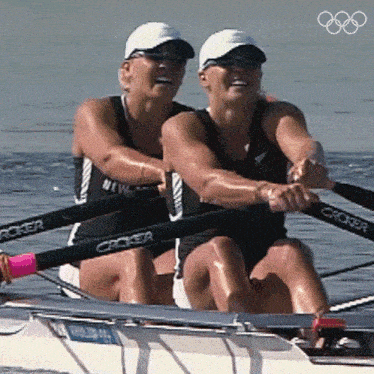two women are rowing a boat with the word crocker on the handles