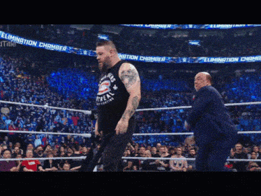two men in a wrestling ring with a banner that says elimination chamber in the background
