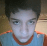 a close up of a boy 's face with a blue shirt on .