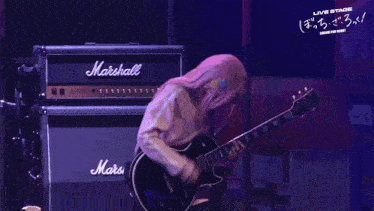 a man is playing a guitar in front of a marshall amplifier