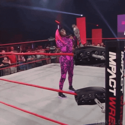 a woman in a purple outfit is standing in a wrestling ring next to an impact wrestling ring post
