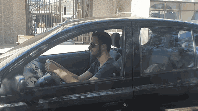 a man sitting in a car with a bottle of water in his hand