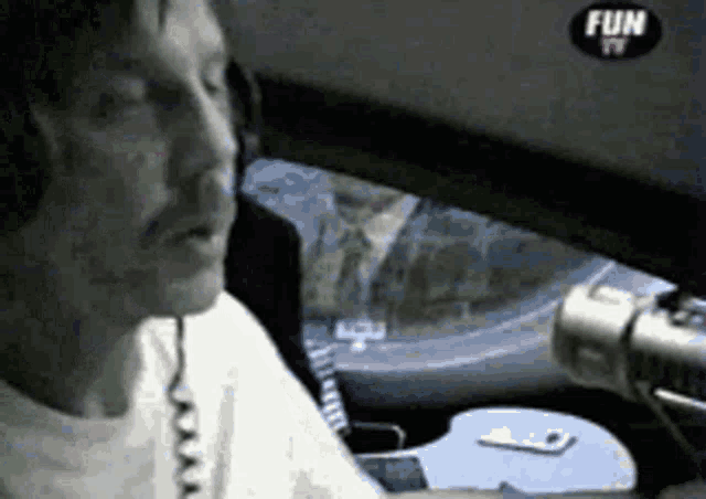 a man sitting in a car with a fun tv logo on the bottom
