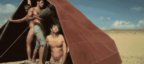 three naked men are standing outside of a tent